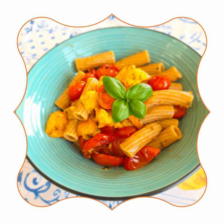 Rigatoni freddi con pomodorini, peperoni gialli e basilico fresco serviti in piatto verde – ricetta estiva mediterranea semplice e colorata
