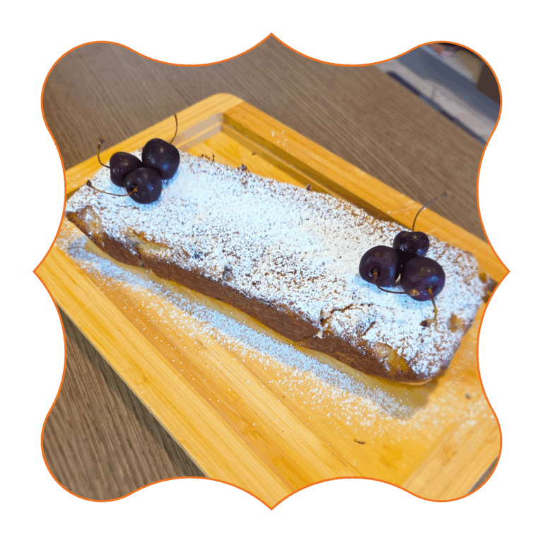 Plum cake fit alle ciliegie con zucchero a velo e ciliegie fresche su tagliere di legno
