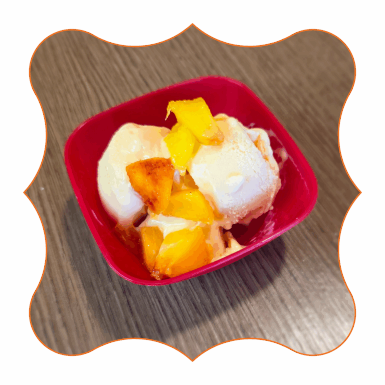 Gelato fit alle pesche e mango con cubetti di frutta fresca servito in coppetta rossa